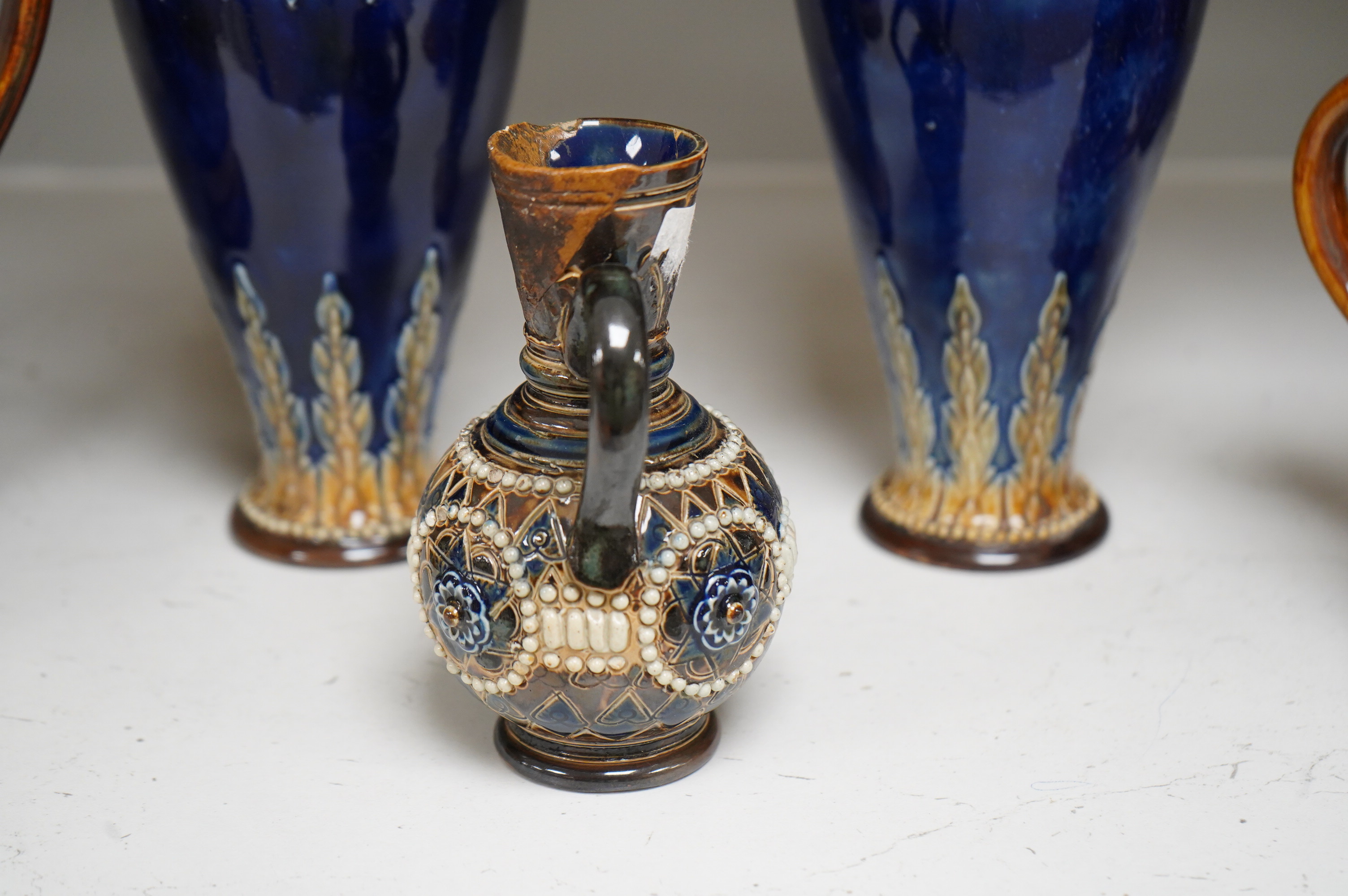 A Doulton Lambeth stoneware commemorative pitcher of William Ewart Gladstone 23cm high, together with a pair of vases two handled vase and a mug, (5).